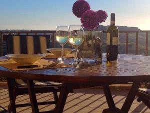 una mesa de madera con copas de vino y una botella de vino en The Heights 2 Bedroom Apartment, en Għasri