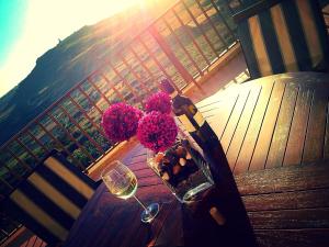 una mesa con flores y una copa de vino en el balcón en The Heights 2 Bedroom Apartment, en Għasri