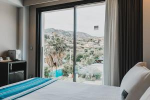 a bedroom with a bed and a large glass window at H Boutique Peña Parda in La Herradura