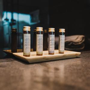 a group of four bottles of seasoning on a cutting board at H Boutique Peña Parda in La Herradura
