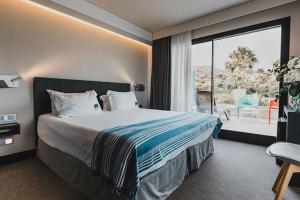 a hotel room with a bed and a large window at H Boutique Peña Parda in La Herradura +37 photos
