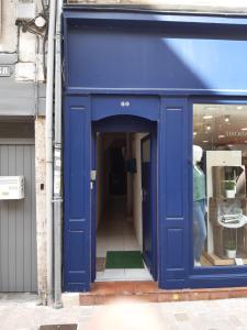 Eine blaue Tür eines Ladens mit einem Mann, der da reingeht. in der Unterkunft Le Studio de Sophie in Vendôme