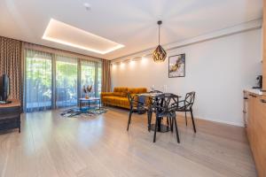 a living room with a table and a couch at Cuprum Poilsis in Palanga