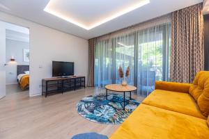 a living room with a couch and a tv at Cuprum Poilsis in Palanga