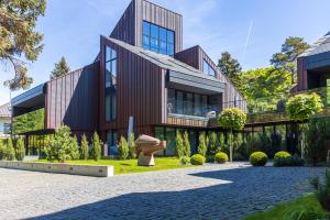 a large building with a garden in front of it at Cuprum Poilsis in Palanga