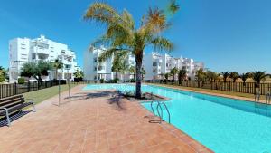 a swimming pool with a palm tree and some buildings at Casa Arancha - A Murcia Holiday Rentals Property in Roldán