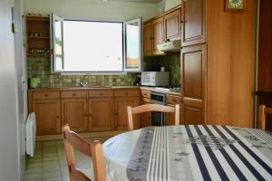 cocina con mesa y ventana en Maison idéale pour des vacances en famille revigorantes à Brem-sur-Mer, en Brem-sur-Mer