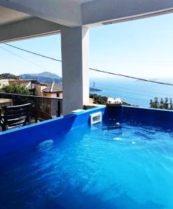 a large blue swimming pool with a view of the ocean at Aren Guest House in Kalkan in Kas