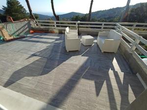 a deck with two white chairs on a roof at Casa Jonorunn in Nibbiaia