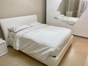 a white bed in a room with a mirror at Casa Jonorunn in Nibbiaia