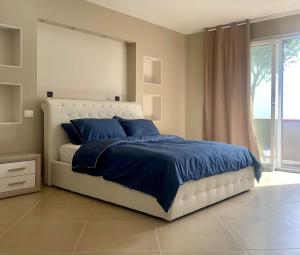 a bedroom with a bed with blue sheets and a window at Casa Jonorunn in Nibbiaia