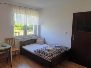 een kleine slaapkamer met een bed en een raam bij POKOJE U MIKOŁAJA in Kamień Pomorski