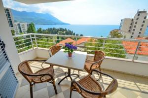 een balkon met een tafel en stoelen en de oceaan bij Apartments Ivanović in Budva