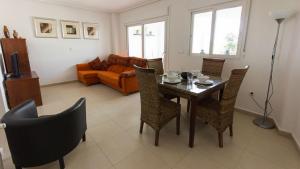 a living room with a table and chairs and a couch at Casa Ricardo - A Murcia Holiday Rentals Property in Roldán