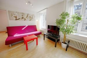 チューリッヒにあるハイトレンタル シュタウファッハー アパートメンツのリビングルーム(赤いベンチ、テレビ付)