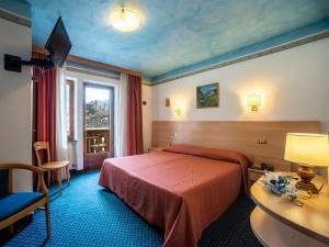 una camera d'albergo con letto e finestra di Hotel Adriana ad Alleghe