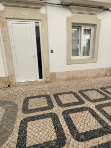 um piso de azulejo em frente a um edifício com uma porta em RG Studio em Faro