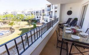 a balcony with tables and chairs and a view of the beach at Casa Jurel - A Murcia Holiday Rentals Property in Roldán