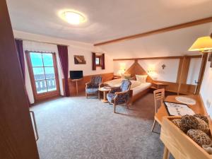 a hotel room with a bed and a table and chairs at Gästehaus Fitsch in Obsteig