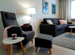 Citykoti Kuutti في سافونلينّا: غرفة معيشة مع كرسيين وأريكة