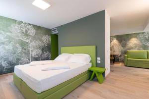 a bedroom with a bed and a green wall at lillil - Popping Holiday in Riva del Garda