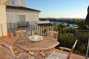 a wooden table and chairs on a balcony with a view of the water at Casa Emperador - A Murcia Holiday Rentals Property in Roldán