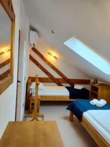 a bedroom with two beds and a sloped ceiling at Casa Dávid Ferenc Ház in Deva