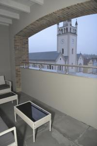 um edifício branco com uma torre do relógio numa varanda em Atmosfera Apartament 4 em Bytów