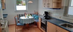 eine Küche mit einem kleinen Tisch und eine Küche mit einem Waschbecken in der Unterkunft Ferienhaus Gänseblümchen in Königstein an der Elbe