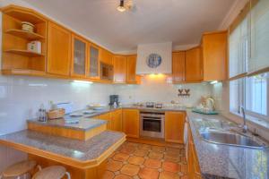 a kitchen with wooden cabinets and a sink at Villa Flor by Villa Plus in Guia