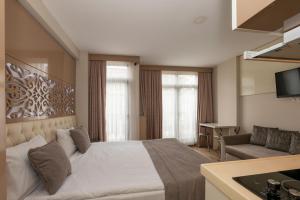 イスタンブールにあるTaksim Peri Suiteのベッドルーム(ベッド1台、ソファ、テレビ付)