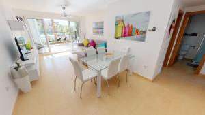a dining room with a glass table and white chairs at Casa Kazamour - A Murcia Holiday Rentals Property in Torre-Pacheco