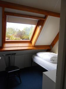 een kleine kamer met een bed en een raam bij Garden cottage Domburg in Domburg