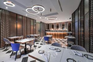 a restaurant with tables and chairs and a bar at Lure Hotel & Spa - Adults Only in Mellieħa