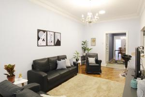 里約熱內盧的住宿－Lindo em Copacabana - Quartos confortáveis - A306 Z3，客厅配有黑色真皮沙发和椅子