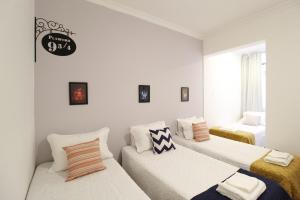 Duas camas num quarto com paredes brancas em Lindo em Copacabana - Quartos confortáveis - A306 Z3 no Rio de Janeiro