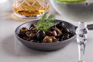 a bowl of mushrooms on a table with a glass of wine at Lure Hotel & Spa - Adults Only in Mellieħa