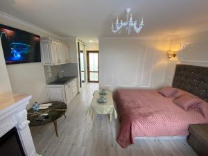 ein Schlafzimmer mit einem großen Bett und einem Tisch in der Unterkunft NESS готельно-ресторанний комплекс in Luzk