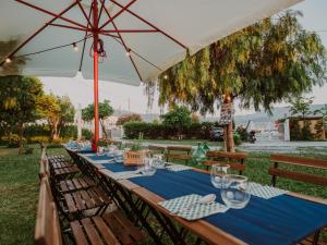 a long table under an umbrella with glasses and napkins at Dimora Santo Stefano in Pompei