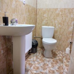 bagno con servizi igienici bianchi e lavandino di KOMFORT a Berehove