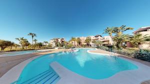 - une piscine dans un complexe avec des palmiers et des maisons dans l'établissement Casa Atalya - A Murcia Holiday Rentals Property, à Torre-Pacheco