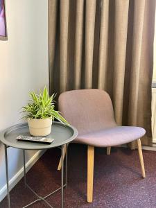 a chair sitting next to a table with a plant at HOTEL N Hostel Malmö City in Malmö