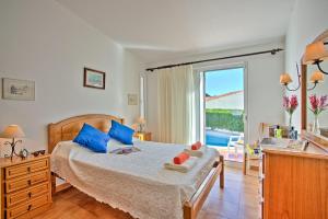 ein Schlafzimmer mit einem Bett mit blauen Kissen und einem Fenster in der Unterkunft Villa Vitor by Villa Plus in Albufeira