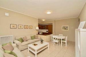 un soggiorno con divano e tavolo di Contempora Apartments - Ca' Brenta Garden a San Fedele Intelvi