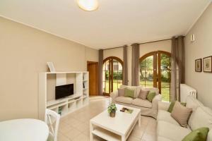 un soggiorno con divano e TV di Contempora Apartments - Ca' Brenta Garden a San Fedele Intelvi