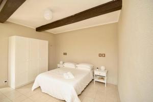 una camera bianca con letto e comodino di Contempora Apartments - Ca' Brenta Garden a San Fedele Intelvi