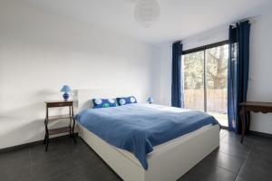 a bedroom with a bed with blue sheets and a window at Maison neuve pour 4 adultes - 2 enfants - Jardin in Piriac-sur-Mer