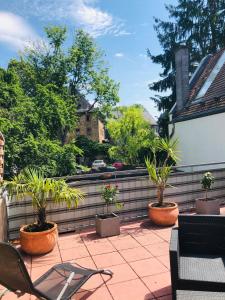 eine Terrasse mit Topfpflanzen auf einem Zaun in der Unterkunft Altstadt Hotel Glockenhof in Eltville