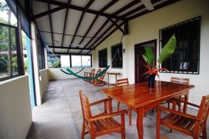 a dining room with a wooden table and chairs at Pavones Point Surf House in Great Location in Pavones