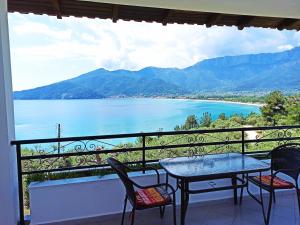 a balcony with a table and chairs and a view of a lake at Studios Maria in Chrysi Ammoudia